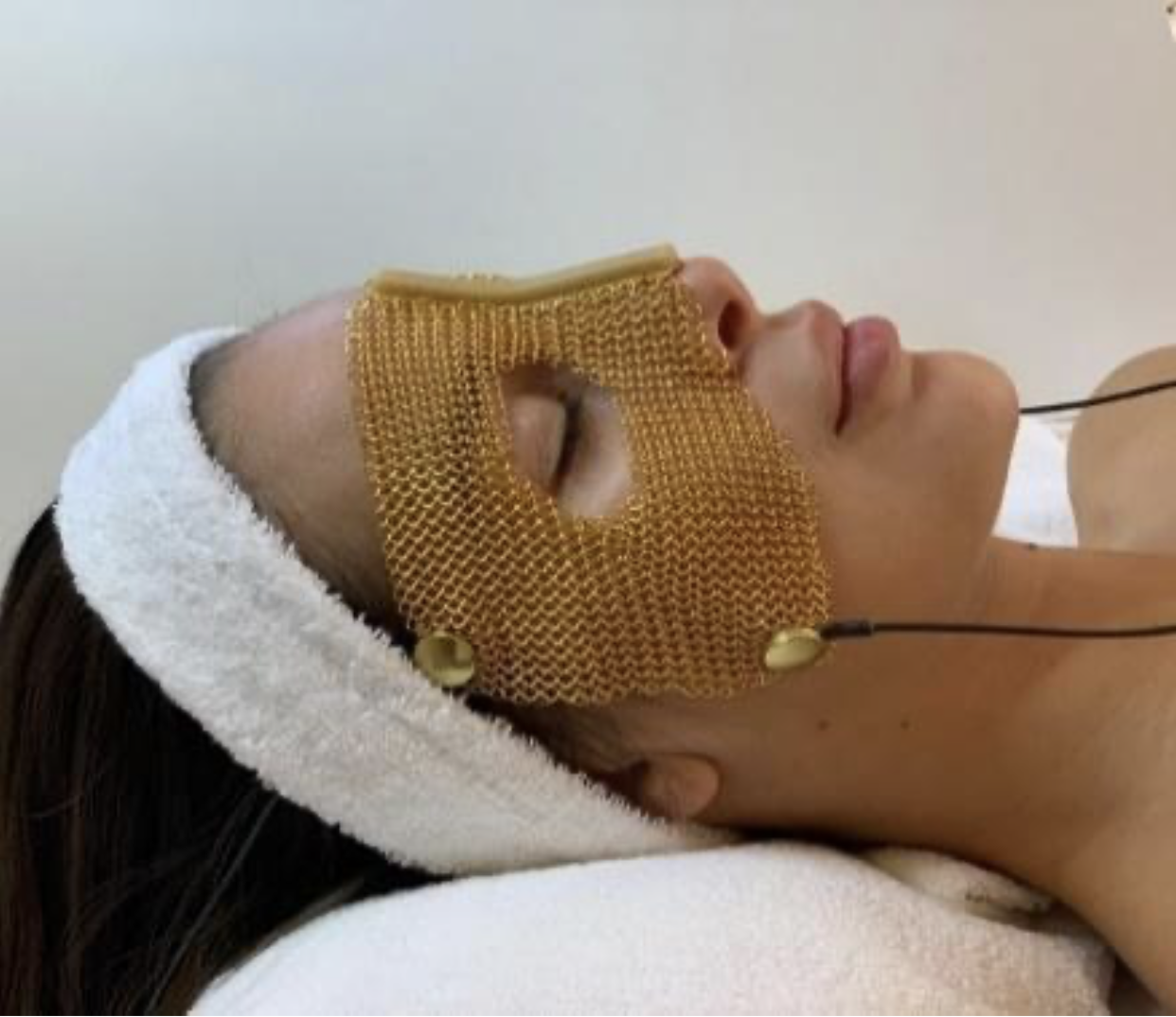 OndaLuz: Goldnetzmaske über den Augen einer Frau zur ganzheitlichen Entspannung und Regeneration